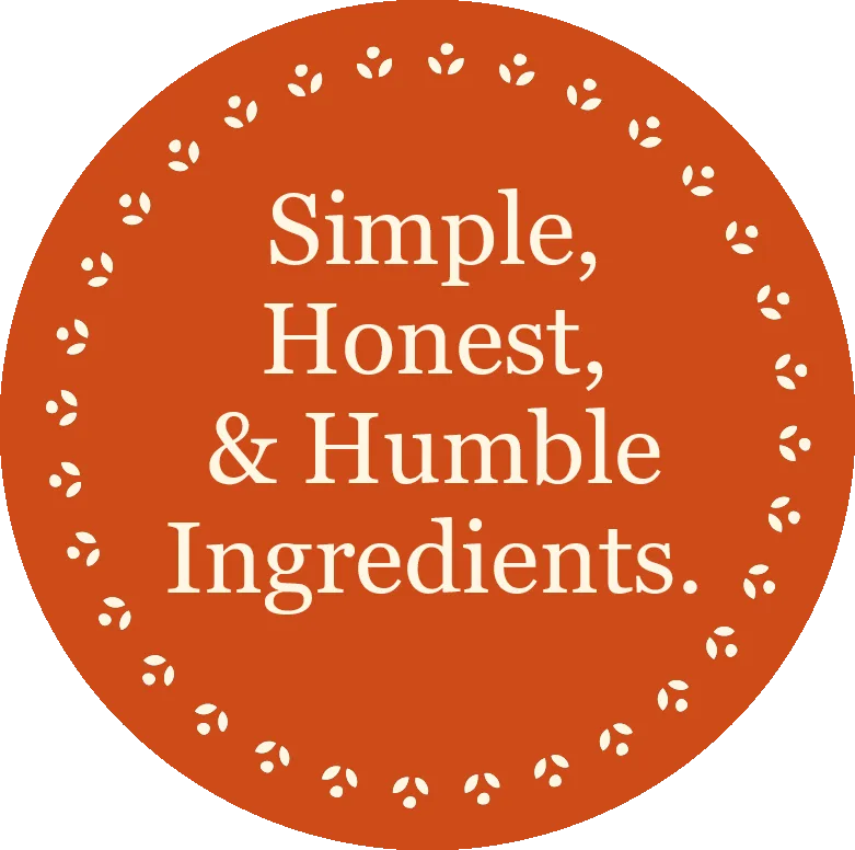 Orange circular badge with white leaf border displaying 'Simple, Honest, & Humble Ingredients' text.